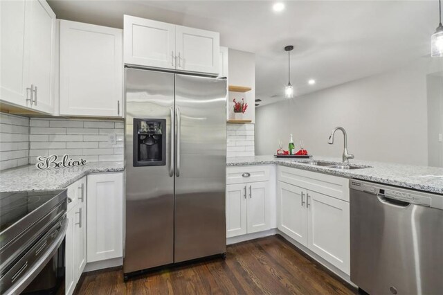 kitchen with appliances with stainless steel finishes, dark wood-type flooring, sink, pendant lighting, and white cabinetry