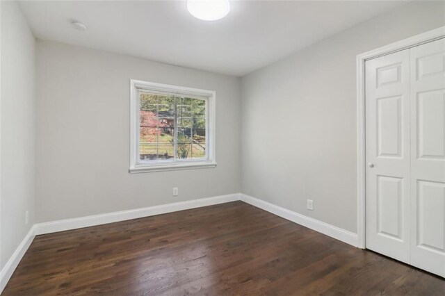 empty room with dark hardwood / wood-style flooring