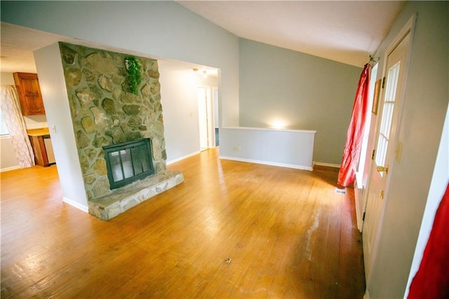 4190 Heather Way, Cumming, GA 30041 - unfurnished living room featuring lofted ceiling, wood finished floors, a stone fireplace, and baseboards