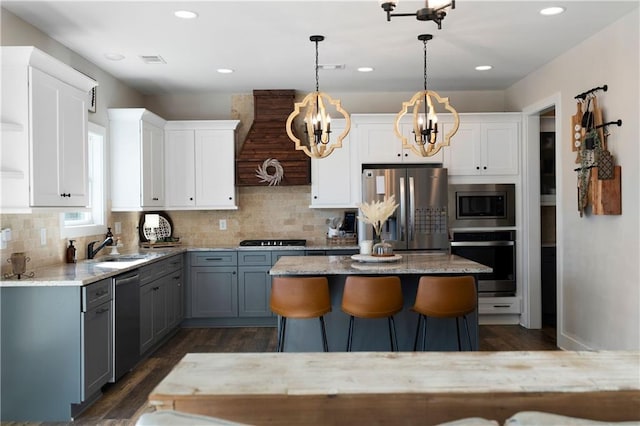 kitchen featuring gray cabinets, white cabinetry, stainless steel appliances, and an inviting chandelier