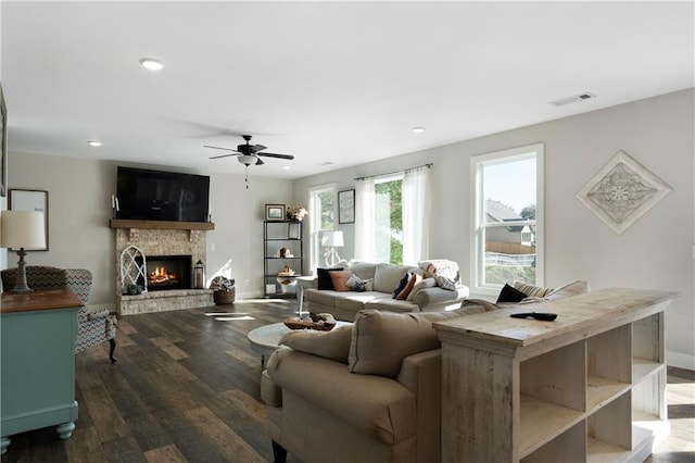 living room with a fireplace, dark hardwood / wood-style flooring, and ceiling fan