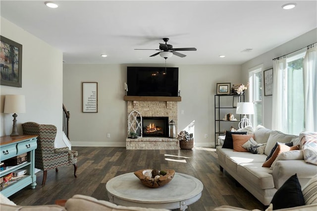 living room featuring a fireplace, ceiling fan, and dark hardwood / wood-style flooring