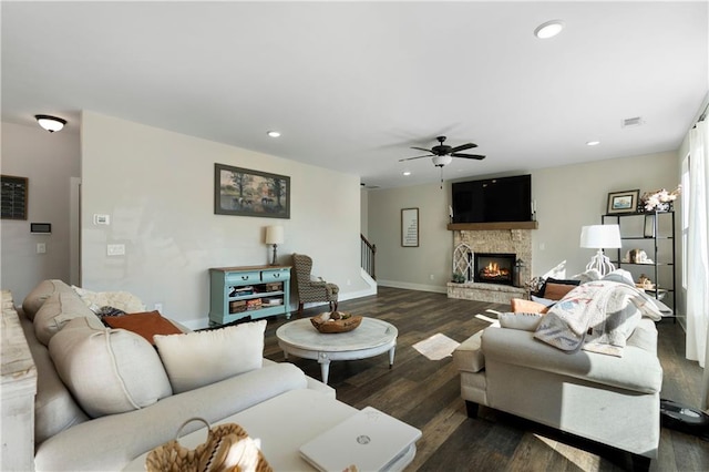 living room with a fireplace, dark hardwood / wood-style floors, and ceiling fan