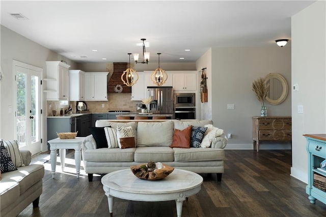 living room with dark hardwood / wood-style flooring, an inviting chandelier, and sink