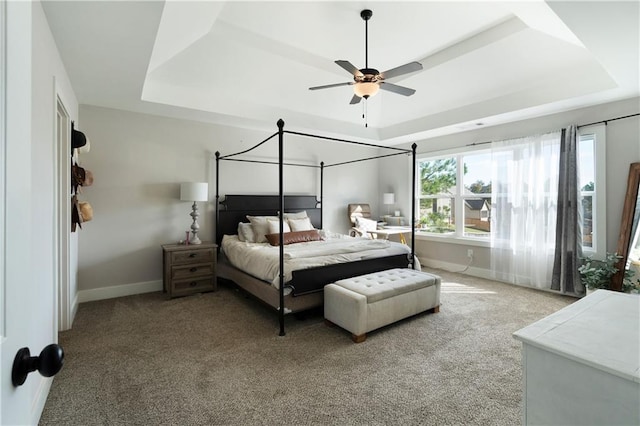 bedroom with carpet floors, a tray ceiling, and ceiling fan