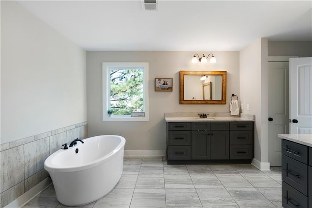 bathroom featuring a bathtub, vanity, and tile walls