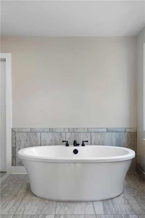 bathroom featuring tile walls and a bathing tub