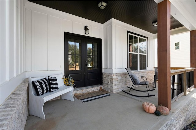 view of exterior entry with a porch and french doors