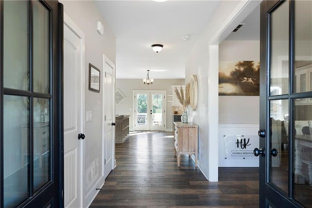 hallway featuring a chandelier, dark wood-type flooring, and french doors