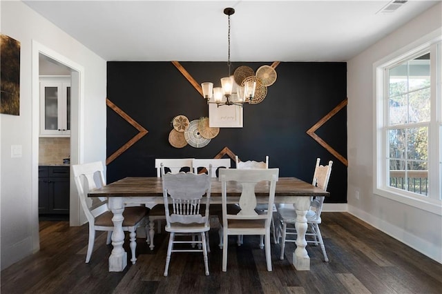 dining space featuring dark hardwood / wood-style floors and an inviting chandelier