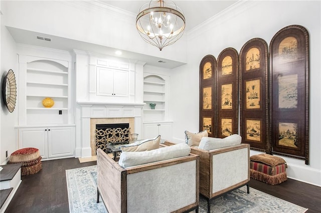 living area featuring a notable chandelier, ornamental molding, dark wood-type flooring, and built in shelves