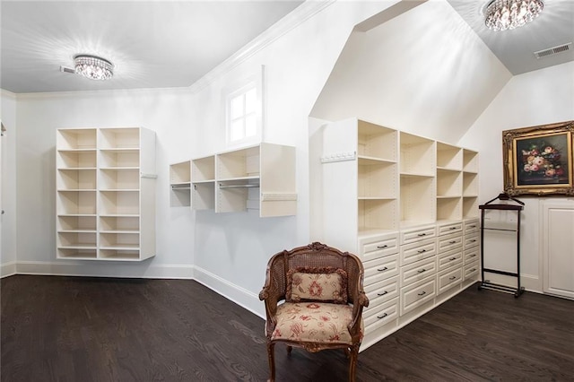 spacious closet featuring dark wood-type flooring and a notable chandelier