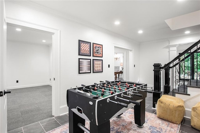 rec room with ornamental molding, decorative columns, and dark colored carpet