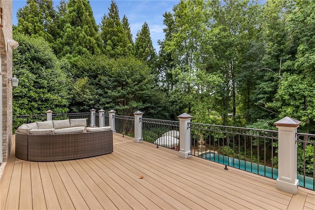 wooden deck with an outdoor living space and a pool