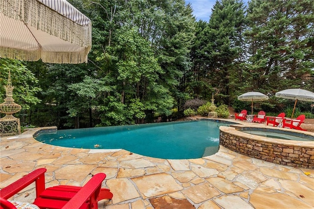 view of swimming pool featuring an in ground hot tub and a patio area