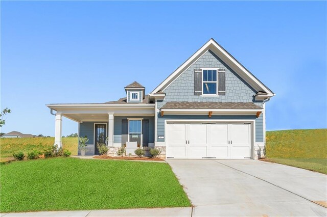 craftsman-style home with a porch, a garage, and a front lawn