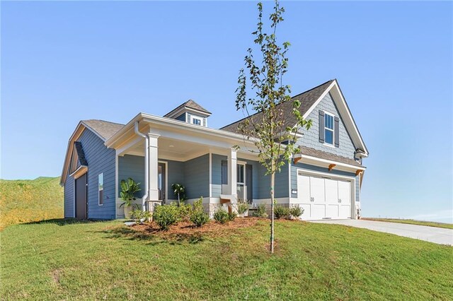 view of front of home featuring a front lawn, a porch, and a garage