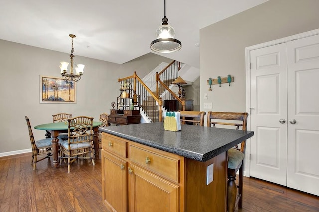 kitchen with dark wood-type flooring, a center island, and hanging light fixtures