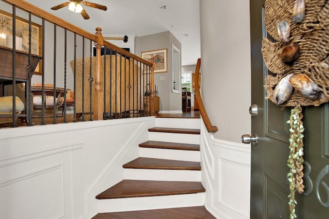 stairs featuring hardwood / wood-style flooring and ceiling fan