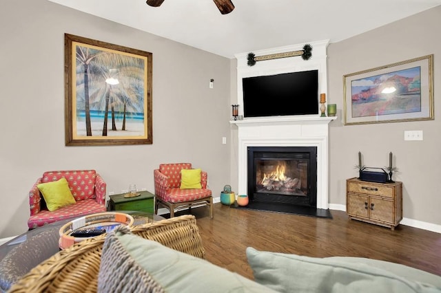 living room featuring dark wood-type flooring and ceiling fan