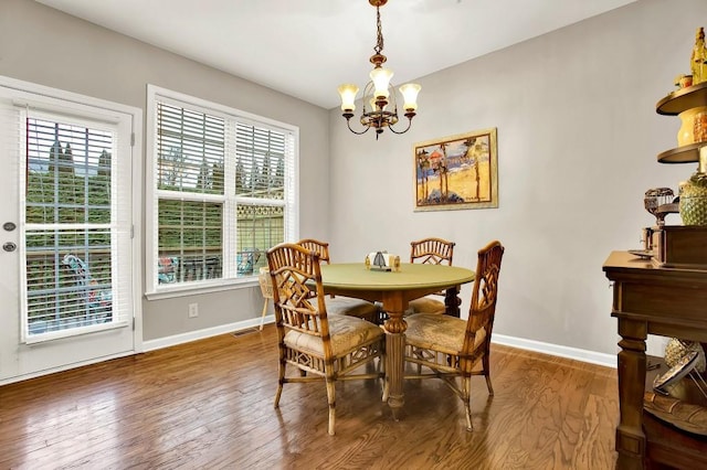 dining room featuring hardwood / wood-style floors and an inviting chandelier