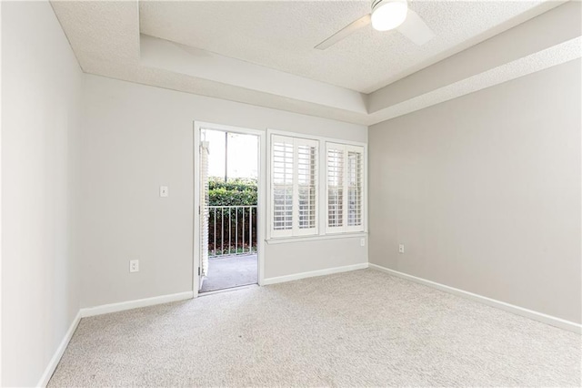 spare room featuring a textured ceiling, carpet floors, ceiling fan, and baseboards