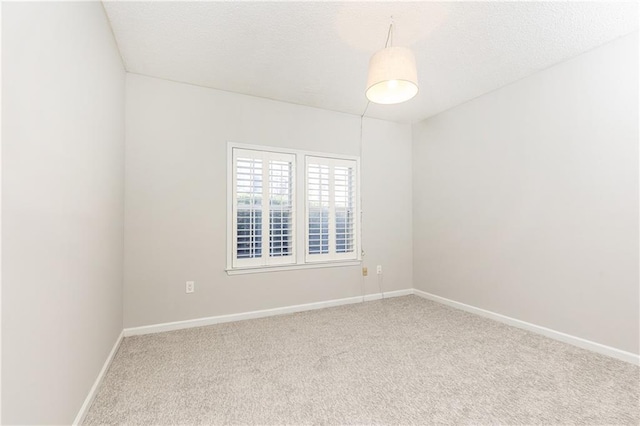 unfurnished room with carpet and baseboards