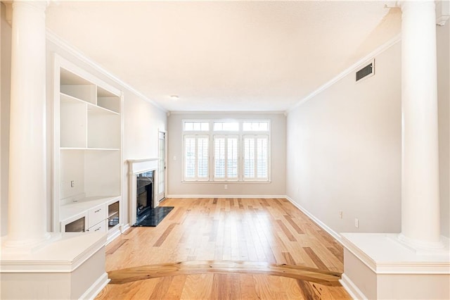 unfurnished living room featuring visible vents, ornamental molding, light wood-type flooring, and decorative columns