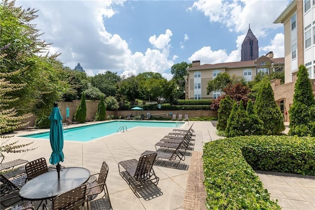 pool with a patio and fence