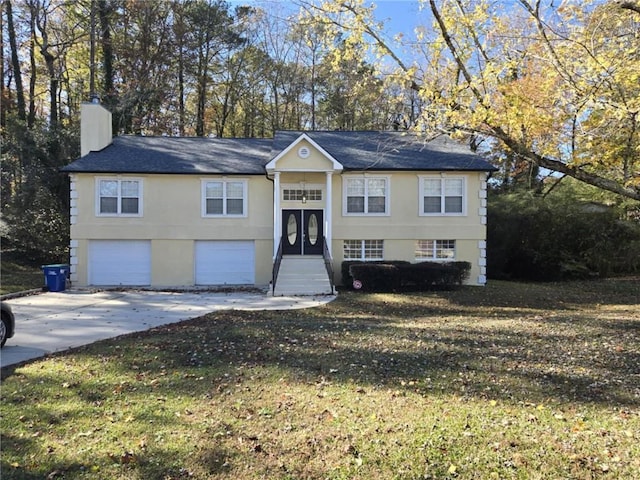 split foyer home featuring a garage and a front lawn