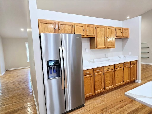 kitchen with light hardwood / wood-style flooring and stainless steel fridge with ice dispenser