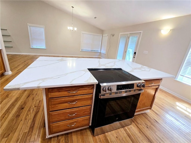 kitchen featuring decorative light fixtures, stainless steel electric stove, a center island, and vaulted ceiling