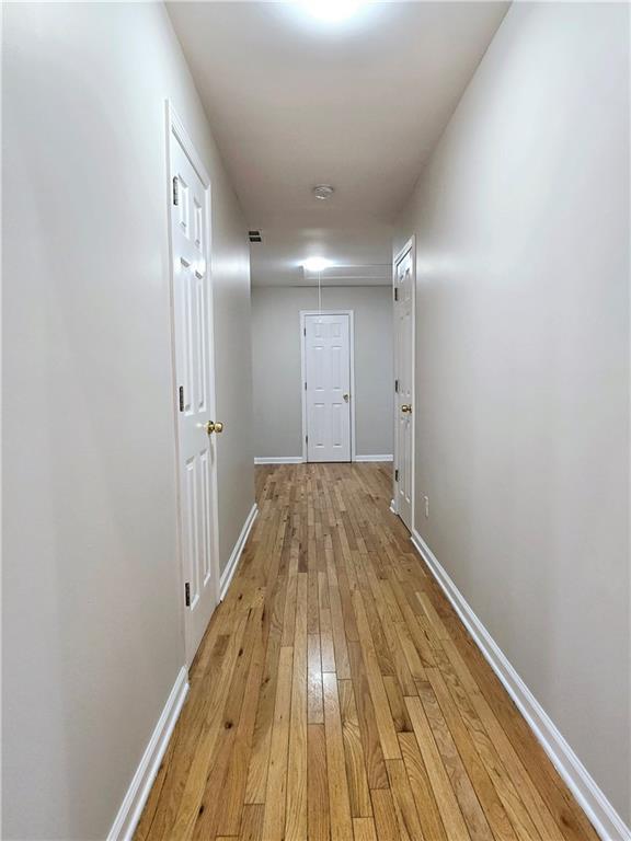 hallway with light hardwood / wood-style floors