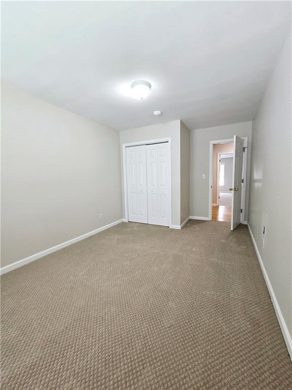 unfurnished bedroom with carpet floors and a closet