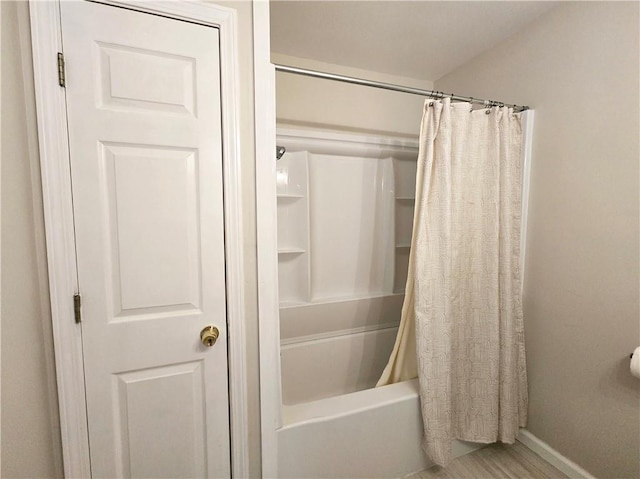 bathroom featuring hardwood / wood-style flooring and shower / bathtub combination with curtain