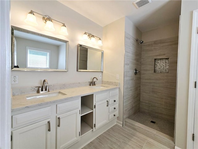 bathroom featuring vanity and tiled shower