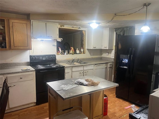 10199 Starr St SW, Covington, GA 30014 - kitchen featuring black appliances, a sink, light wood-style flooring, white cabinetry, and a textured ceiling