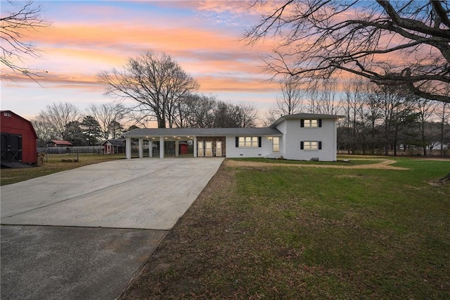 view of front of home with a carport and a lawn