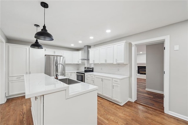 kitchen featuring decorative backsplash, stainless steel appliances, sink, white cabinets, and an island with sink