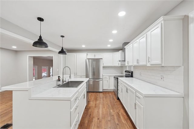 kitchen with sink, decorative backsplash, appliances with stainless steel finishes, decorative light fixtures, and white cabinetry