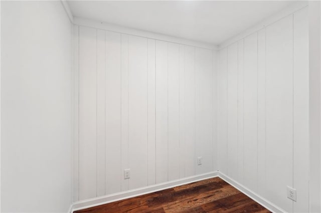 spare room featuring dark hardwood / wood-style flooring and crown molding