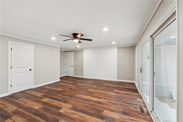 unfurnished bedroom with dark hardwood / wood-style floors, ceiling fan, crown molding, and brick wall