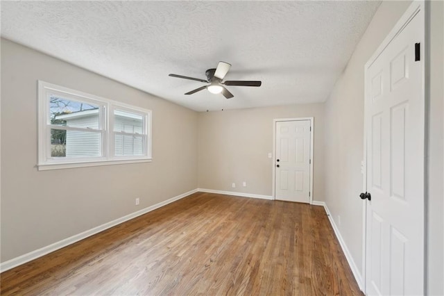 spare room with wood-type flooring, a textured ceiling, and ceiling fan