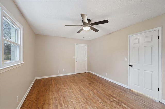 spare room with ceiling fan, light hardwood / wood-style floors, and a textured ceiling