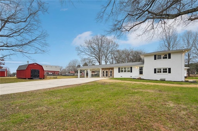 view of front of house featuring a front lawn, an outdoor structure, and a carport