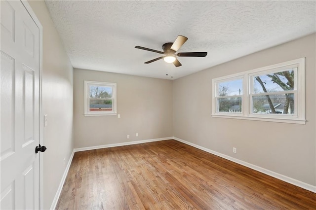 spare room with a textured ceiling, light hardwood / wood-style flooring, and ceiling fan