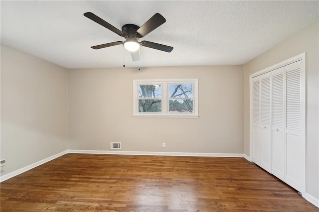 unfurnished bedroom featuring ceiling fan, a closet, and dark hardwood / wood-style floors