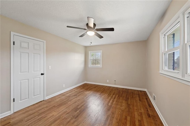 spare room with ceiling fan, wood-type flooring, and a textured ceiling