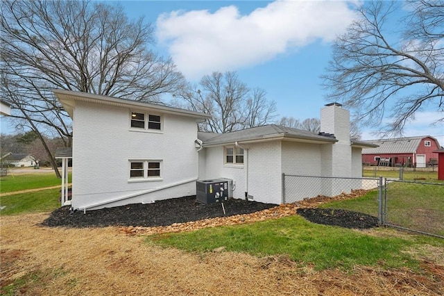 back of house featuring cooling unit and a yard