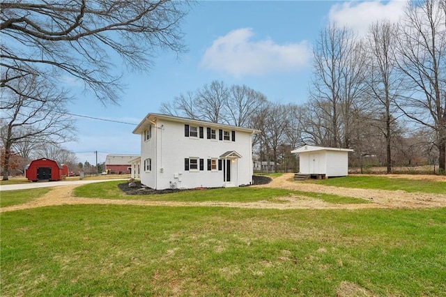 back of house featuring a lawn and a storage unit